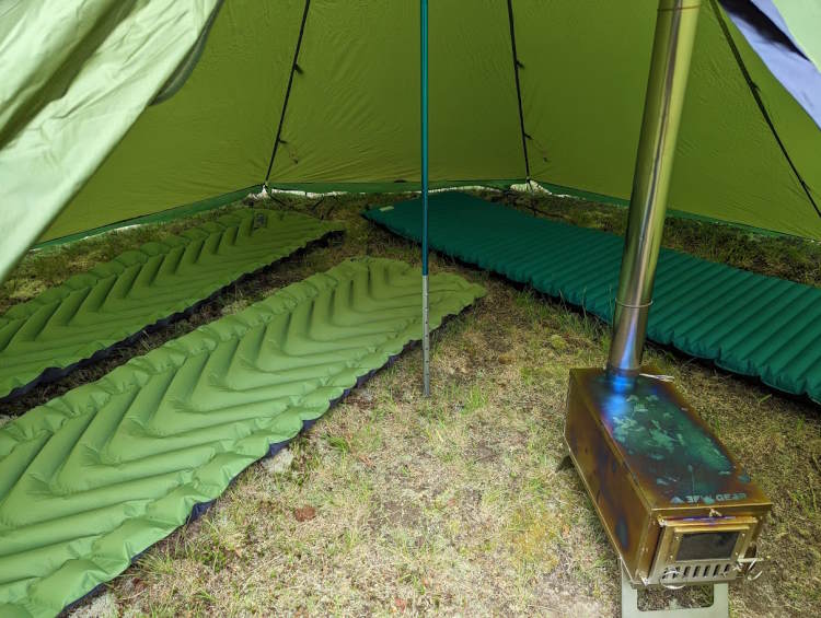 Luxe F8e Winter Shelter with three sleeping mats and wood stove